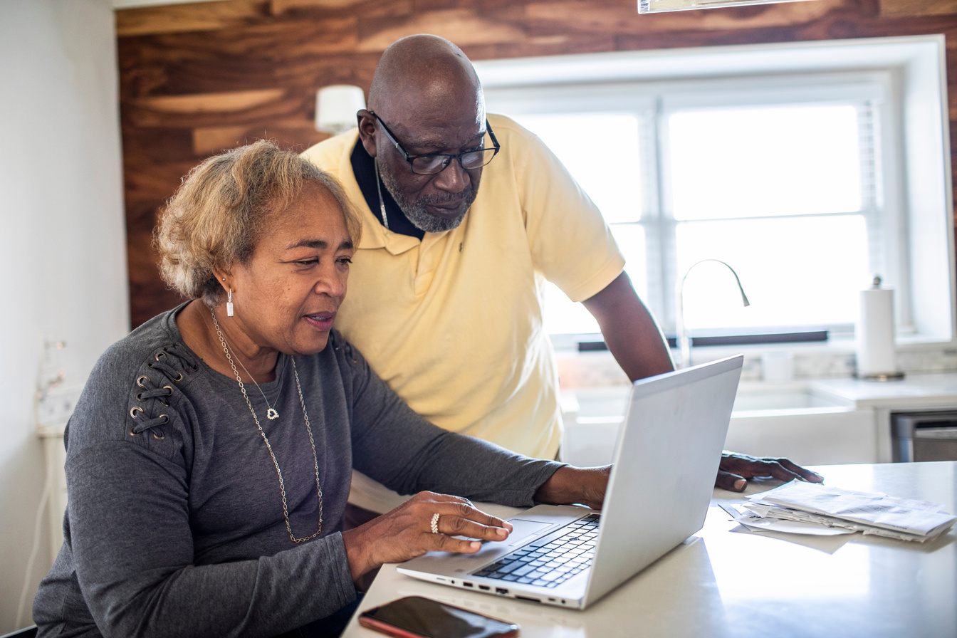 Senior couple using laptop in kitchen